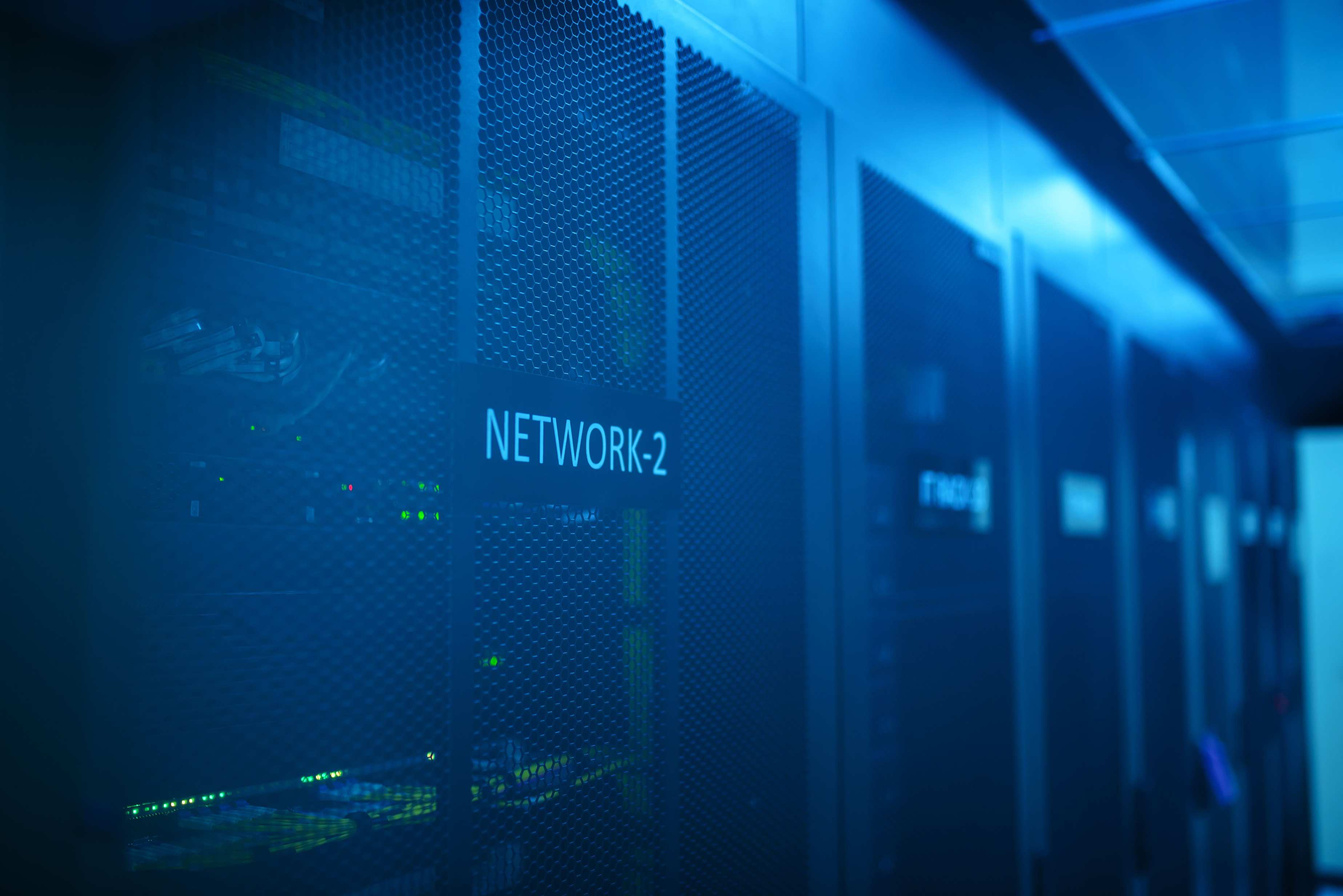 Rows of server racks in a data hall with network equipment